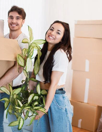 Pareja vaciando su piso en Avilés con cajas y plantas